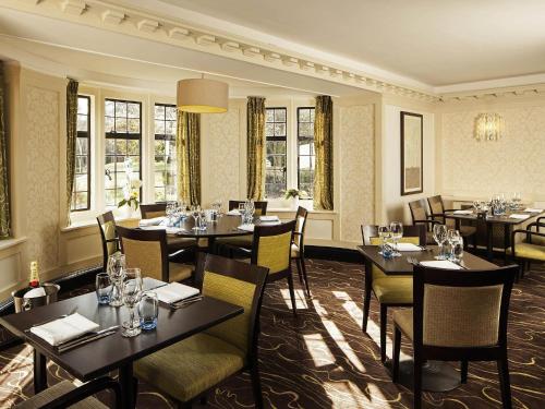 a dining room with tables and chairs and windows at Mercure Tunbridge Wells Hotel in Royal Tunbridge Wells