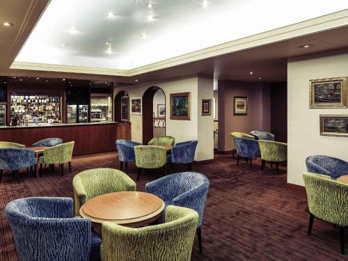 a waiting room with chairs and tables and a bar at Mercure Norwich Hotel in Norwich