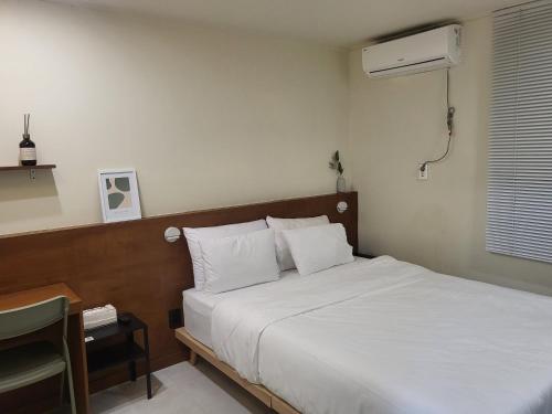 a bedroom with a white bed and a fan at jeonju hotel book and type in Jeonju