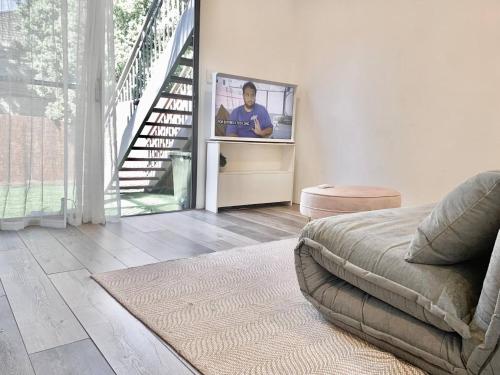 a living room with a tv on a wall at Garden Apartment in the heart of Bondi in Sydney
