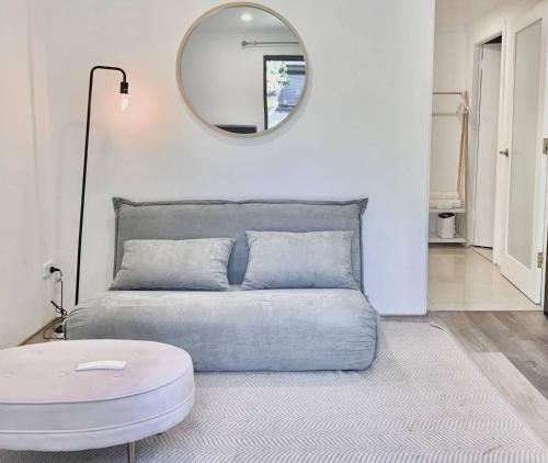 a bedroom with a bed with a round mirror at Garden Apartment in the heart of Bondi in Sydney