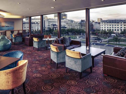 a hotel lobby with couches and tables and windows at Mercure Manchester Piccadilly Hotel in Manchester