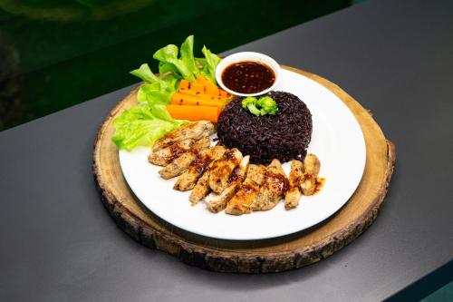a plate of food with meat and vegetables on a table at V1 boutique hotel in Kanchanaburi