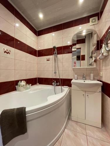 a bathroom with a white tub and a sink at Saules 58 in Ventspils