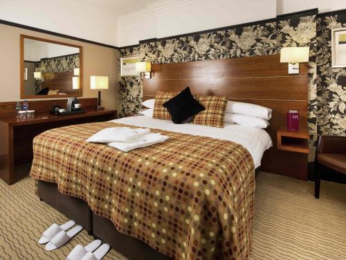 a hotel room with a large bed and a mirror at Mercure Bradford, Bankfield Hotel in Bradford