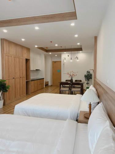 a large bedroom with two beds and a dining room at Seafront Apartment TMS Quy Nhơn in Quy Nhon