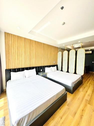 two beds in a hotel room with two bedsvisor at Seafront Apartment TMS Quy Nhơn in Quy Nhon