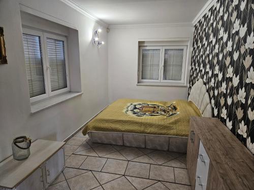 a bedroom with a bed and two windows at Vila Zlatá Přilba in Pardubice