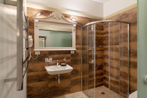 a bathroom with a sink and a shower at Hotel Sinchronas in Telšiai