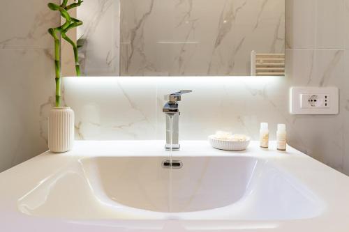 Un lavabo blanco con grifo en un baño. en Aras Luxury Flat, en Roma