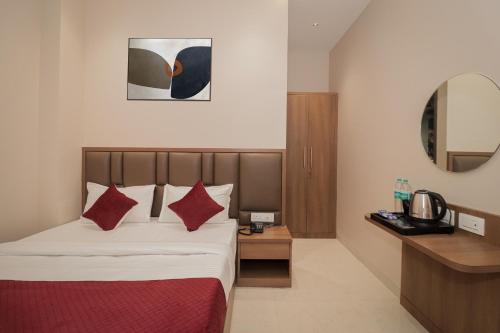 a hotel room with a bed with red pillows at Ascent Star Inn in Mumbai