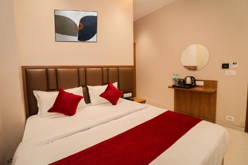 a bedroom with a large bed with red pillows at Ascent Star Inn in Mumbai