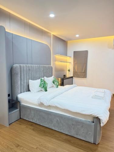 a bedroom with a large white bed with two green pillows at Phupha house Hatyai in Sathani Khlong Rian