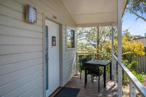 a porch with a table and chairs on it at Thunderbird Motel Yass in Yass
