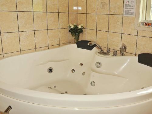 a white bath tub in a bathroom with a vase of flowers at 7 person holiday home in Ansager-By Traum in Ansager
