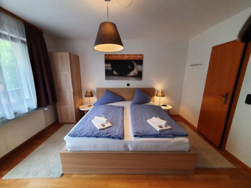 a bedroom with a bed with blue sheets and a lamp at Grüner Baum in Neckargerach