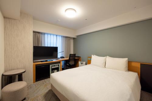 a hotel room with a bed and a flat screen tv at Richmond Hotel Utsunomiya-ekimae Annex in Utsunomiya