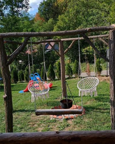 a swing set in a yard with a playground at Cabana AFrame Olanesti in Băile Olăneşti