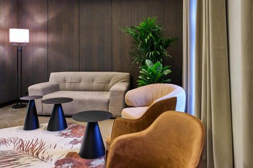 a living room with a couch and chairs and tables at Pullman Riga Old Town in Rīga