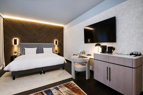 a bedroom with a bed and a desk and a television at Pullman Riga Old Town in Rīga