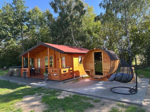 a small log cabin with a playground at Ranczo Rogowo jacuzzi sauna staw rybny in Rogowo
