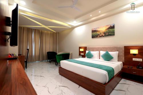 a hotel room with a bed and a television at The Forest Hill Hotel in Haridwār