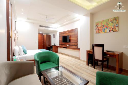 a hotel room with a bed and a desk and chair at The Forest Hill Hotel in Haridwār