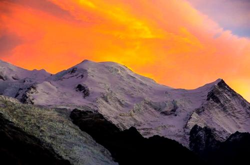 a mountain covered in snow under a cloudy sky at Le Chamois 5E Balcon panoramique MontBlanc avec parking gratuit in Chamonix-Mont-Blanc