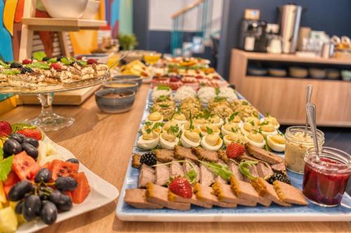 ヴロツワフにあるHotel Villa Art Novis City Centerのテーブルの上にたくさんの料理が並んだビュッフェ