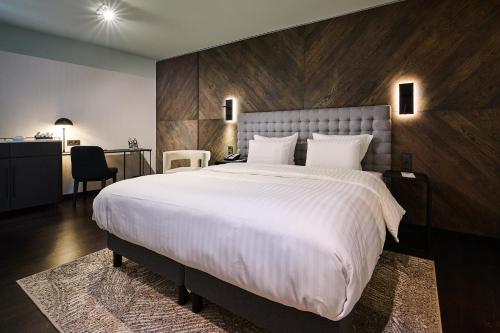 a bedroom with a large bed with a wooden wall at Pullman Riga Old Town in Rīga