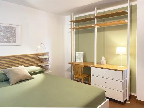 a bedroom with a bed and a dresser and a desk at La Casa nel Bosco - In collina a 10 minuti dal mare in Casarza Ligure