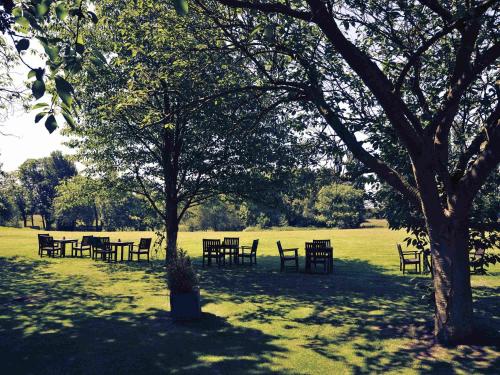 a group of tables and chairs in a park at Mercure York Fairfield Manor Hotel in York