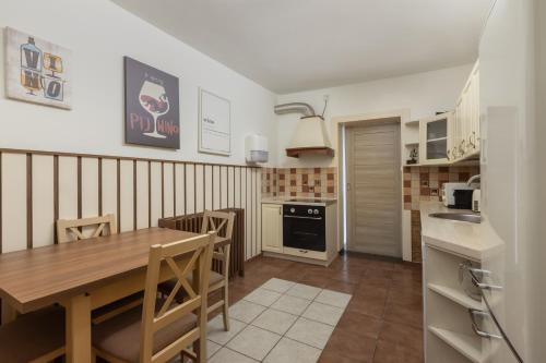 a kitchen with a wooden table and a dining room at Port Rybaki & Vine Agritourism in Brodnica