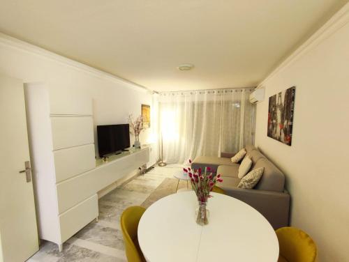a living room with a white table and a couch at Mas de Tanit Appartement & Vacance deLuxe in Antibes