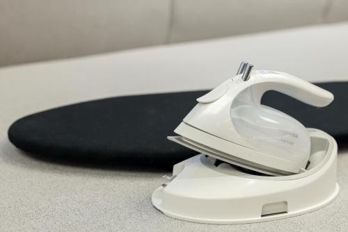 a white hair dryer sitting on the floor next to a skateboard at Richmond Hotel Utsunomiya-ekimae Annex in Utsunomiya