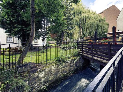 a bridge with a fence next to a park at Mercure Perth Hotel in Perth