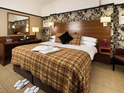 a hotel room with a large bed and a mirror at Mercure Perth Hotel in Perth