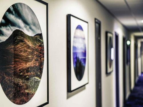 a row of pictures on a wall in a hallway at Mercure Inverness Hotel in Inverness