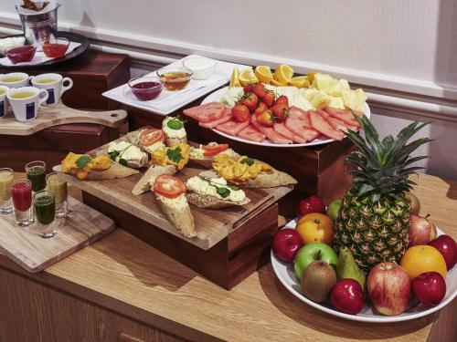 a buffet with three plates of food and fruits at Mercure Inverness Hotel in Inverness