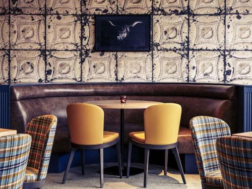 a table and two chairs in a restaurant at Mercure Inverness Hotel in Inverness