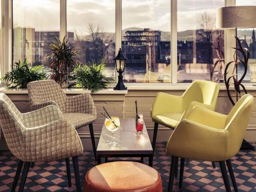 a lobby with chairs and a table and a window at Mercure Inverness Hotel in Inverness