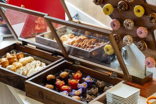 a display case with many different types of donuts at Richmond Hotel Utsunomiya-ekimae Annex in Utsunomiya