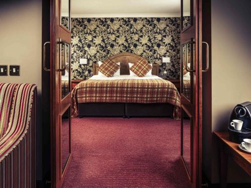 a bedroom with a bed in a room with a doorway at Mercure Maidstone Great Danes Hotel in Maidstone
