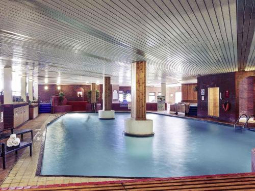 a large swimming pool in a large building at Mercure Maidstone Great Danes Hotel in Maidstone