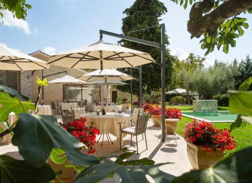 a restaurant with tables and umbrellas in a garden at Boutique Hotel San Rocco in Brtonigla