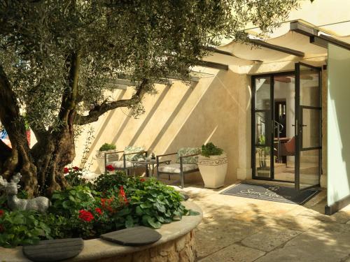 a patio with a tree and flowers in a planter at Boutique Hotel San Rocco in Brtonigla