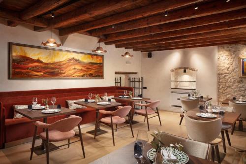 a restaurant with tables and chairs and a painting on the wall at Boutique Hotel San Rocco in Brtonigla