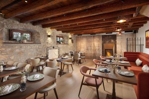 a restaurant with tables and chairs and a fireplace at Boutique Hotel San Rocco in Brtonigla