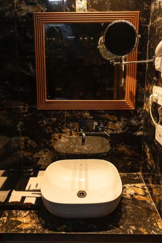 a bathroom with a sink and a mirror at THE FORT in Morādābād