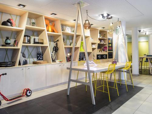 a dining room with a table and yellow chairs at Aparthotel Adagio Access Paris Porte De Charenton in Charenton-le-Pont